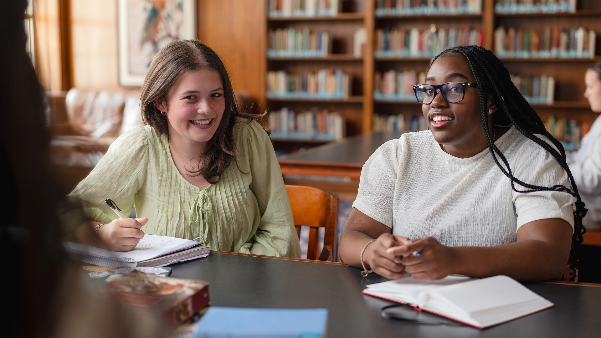 two female students sitting at a desk