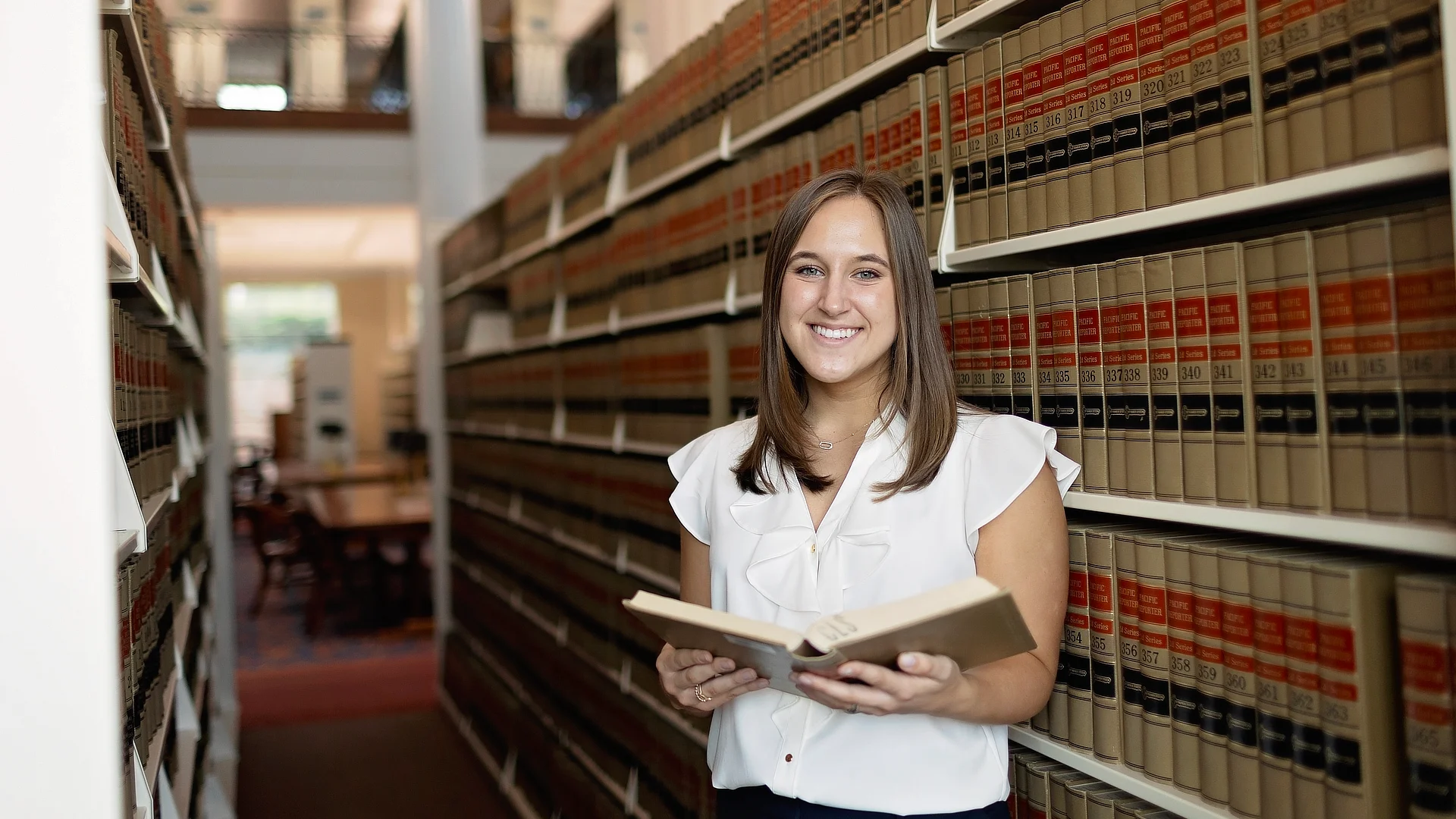 female student in the library reading a book