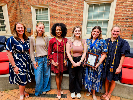 Nia Johnson poses with members of Kappa Tau Alpha.