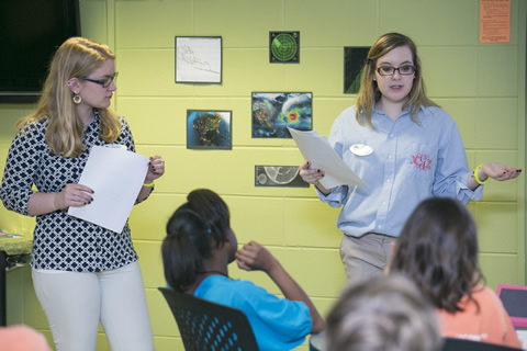 two female students teaching