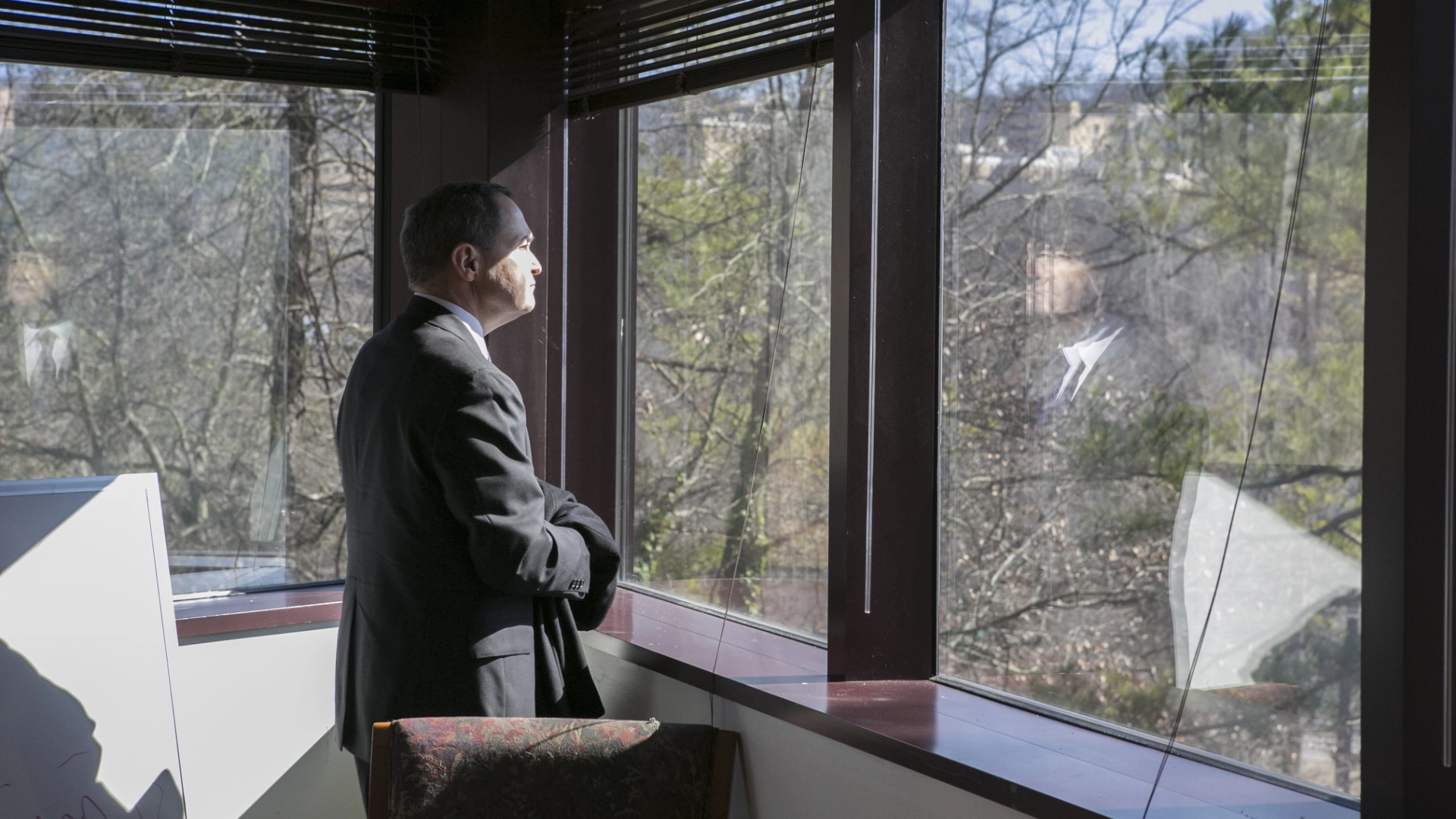 man looking out window