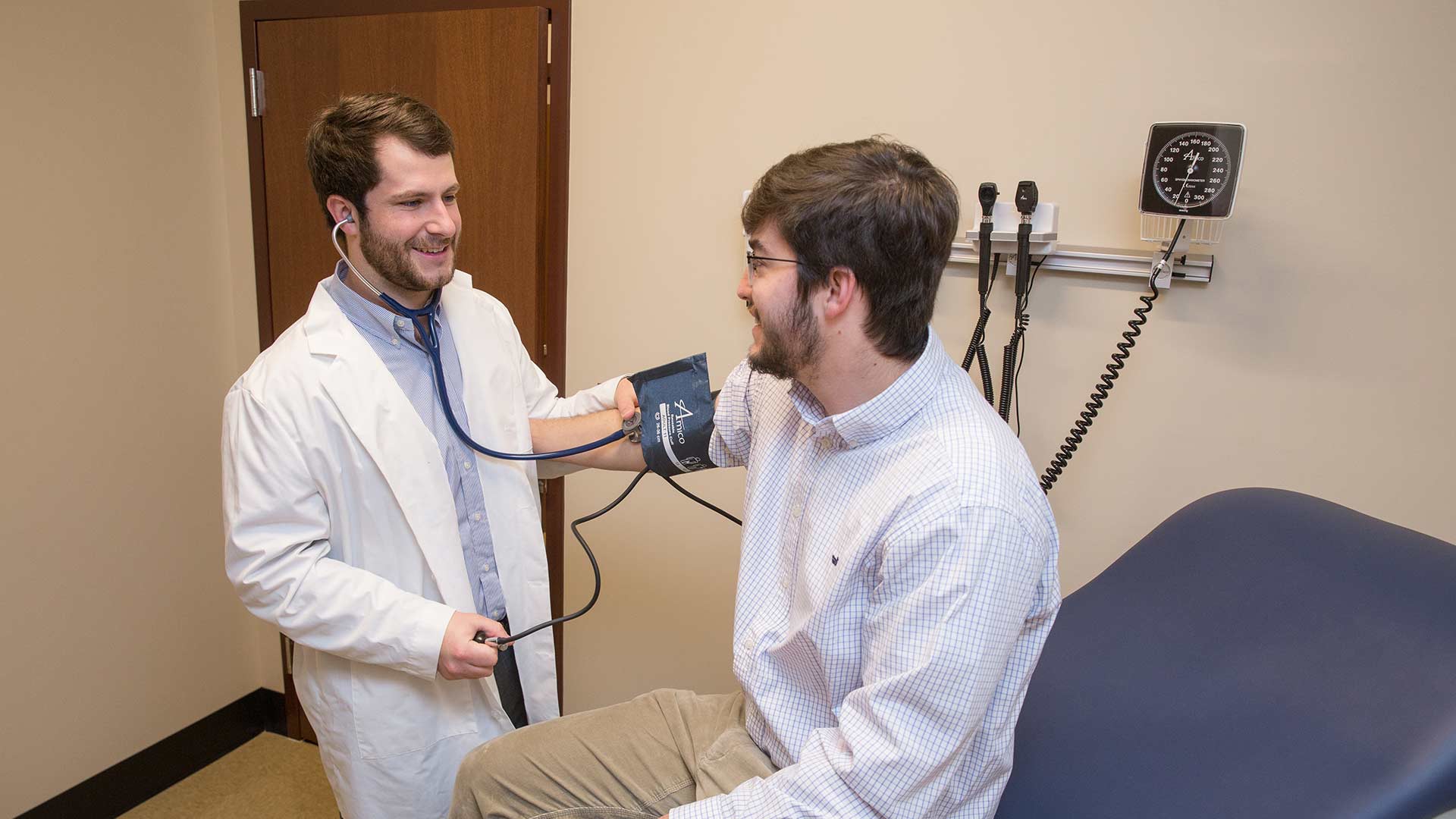 physician assistant taking blood pressure