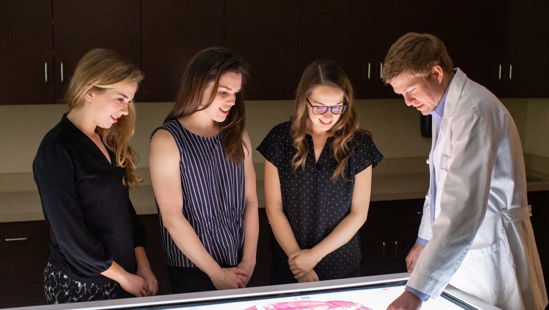 students grouped around professor at anatomage table