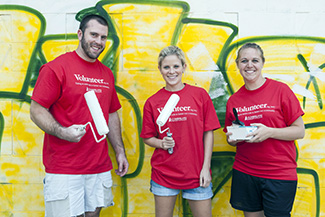 students holding paintbrushes