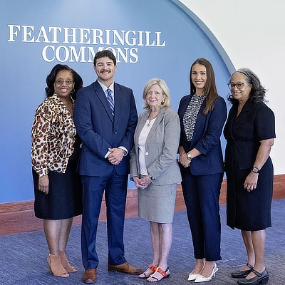 four women and a man standing in the commons area