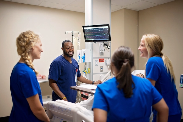 Four Nursing Students Caring For Patient