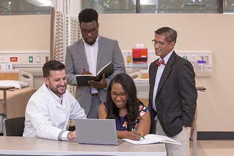 nursing students grouped around laptop