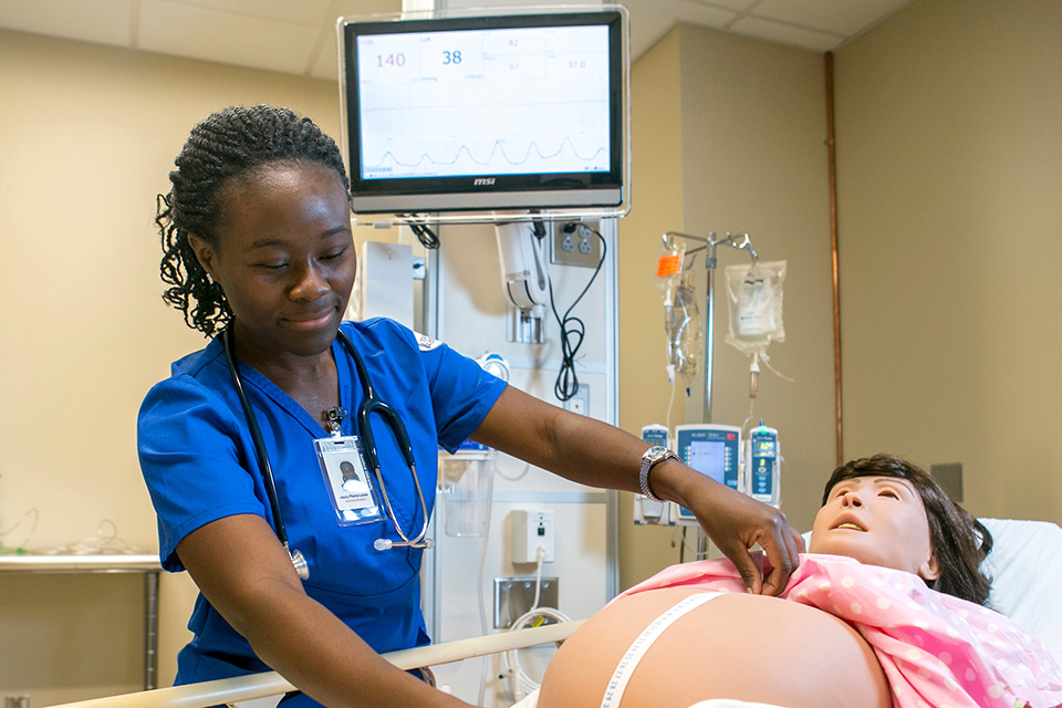 Student working with maternal health care mannikin. 