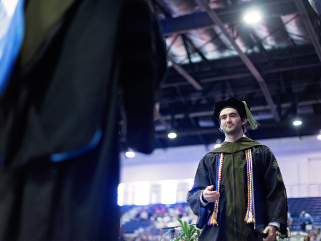 male graduate receiving diploma commencement