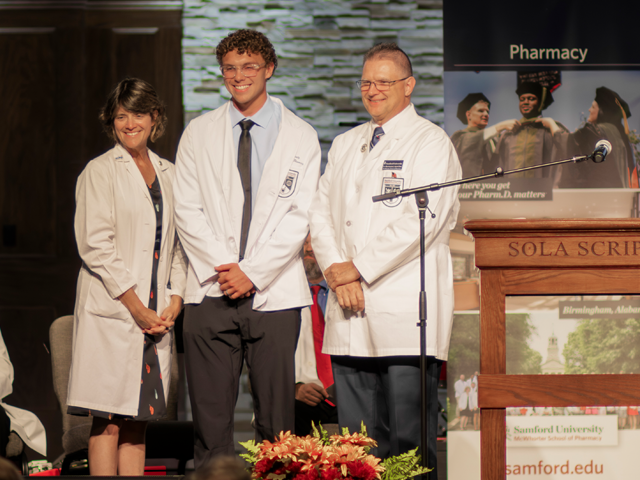male pharmacy student wearing white coat