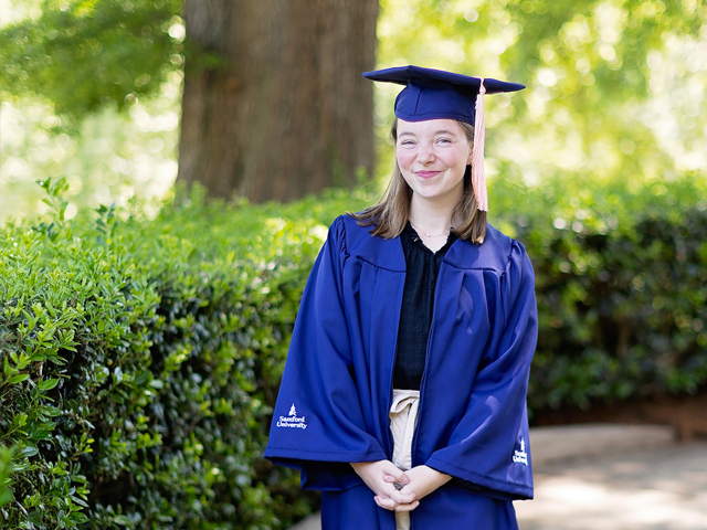 female graduate wearing blue cap and gown