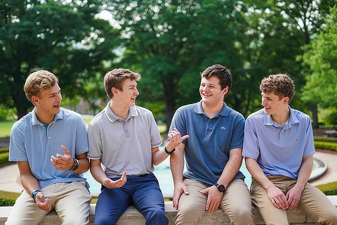 four male students sitting together