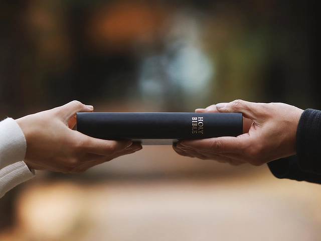 two people holding a bible